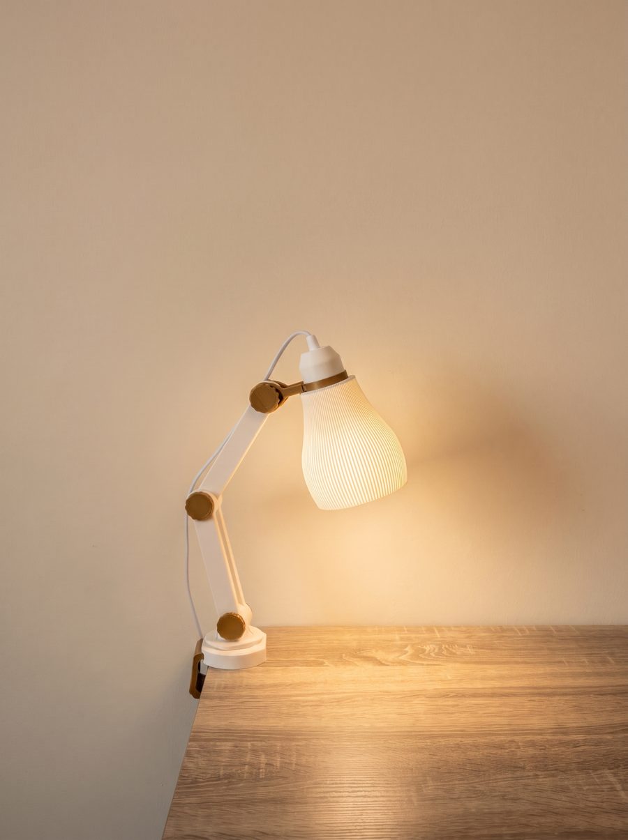DeskLamp with a ribbed shade glowing warm on a wooden desk